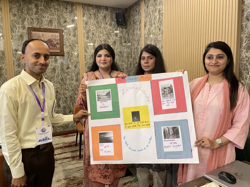 4 participants stand together holding their poster with photos and captions